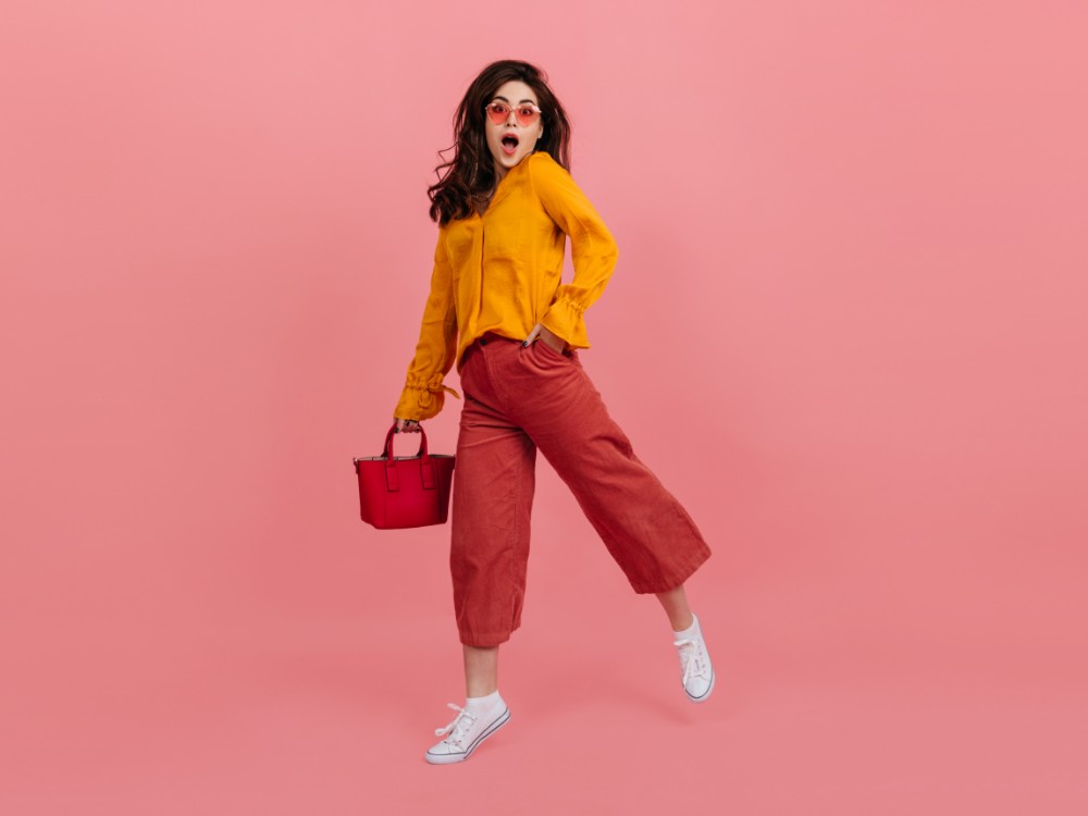 Perky Girl Stylish Glasses Stares Amazement Walking Pink Wall Brunette Culottes Orange Blouse Posing With Red Handbag