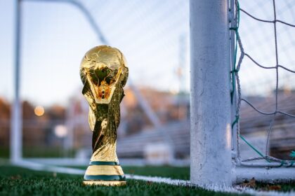 a golden soccer trophy sitting on top of a soccer field