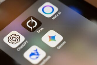 Smartphone screen displays ai app icons: chatgpt, grok, meta ai, gemini.